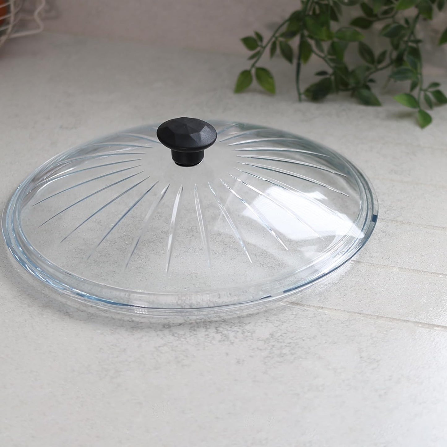 Clear glass pan lid resting on kitchen counter
