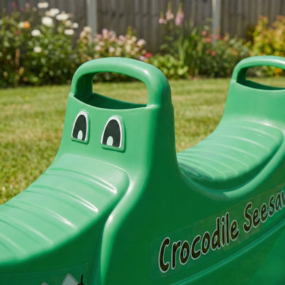 Close-up of the crocodile seesaw's easy-grip handles and friendly eyes