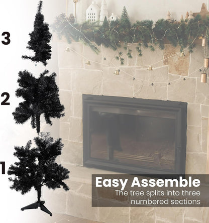Black artificial Christmas tree with assembly instructions next to a fireplace.