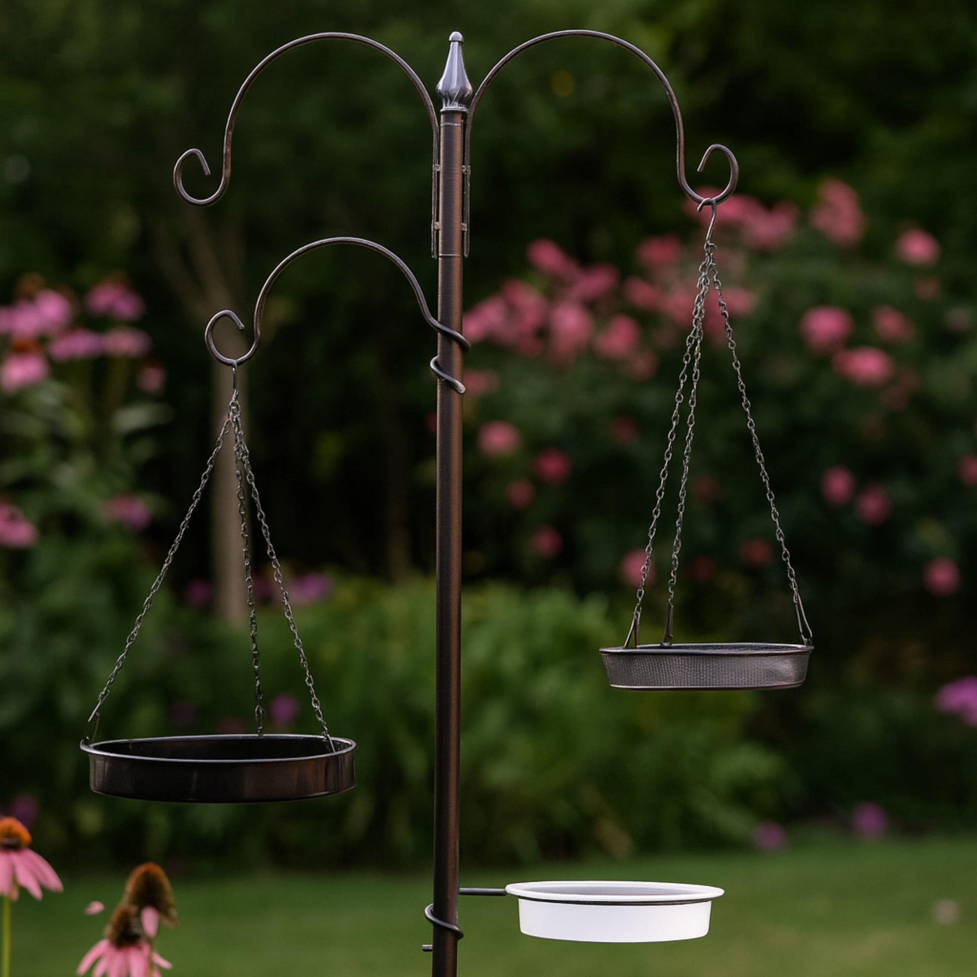 Bird feeder stand with hanging bird baths in a garden setting