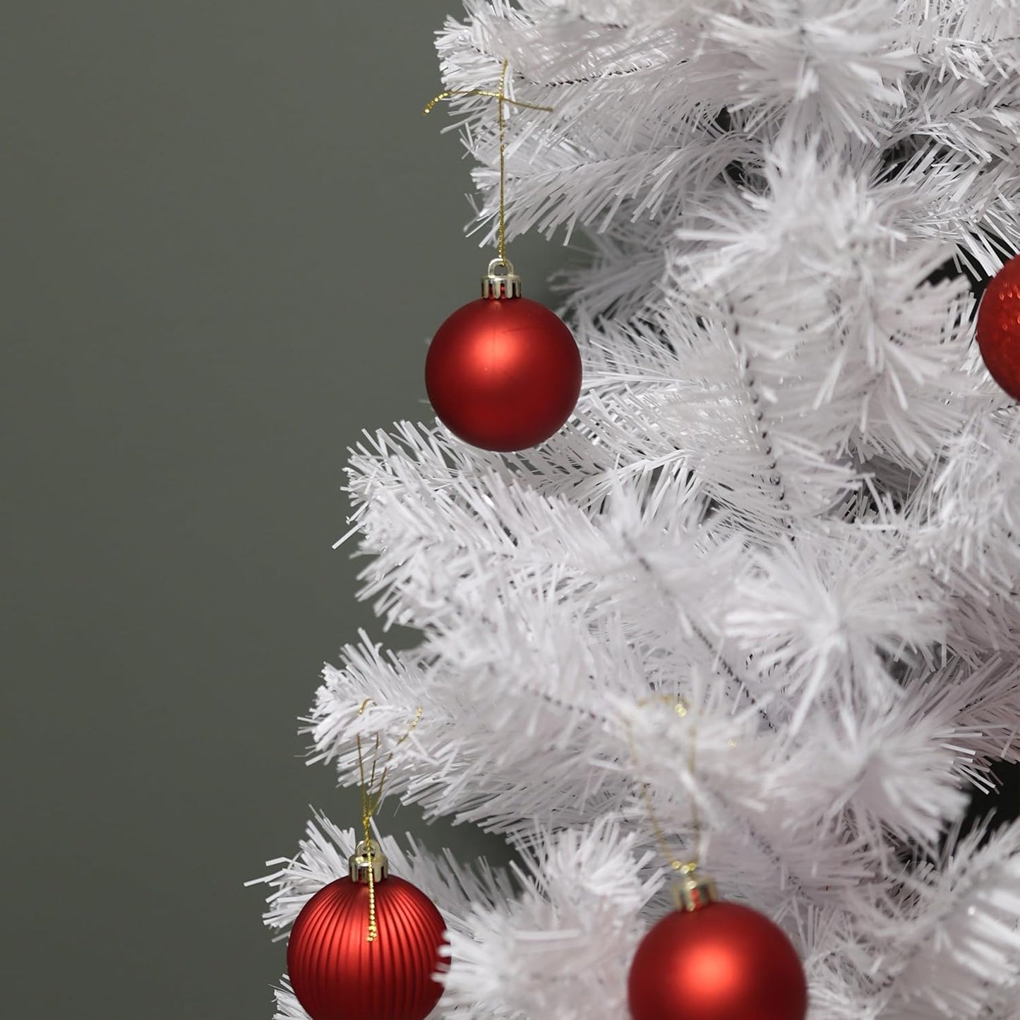 White Christmas tree with red ornaments on a gray background