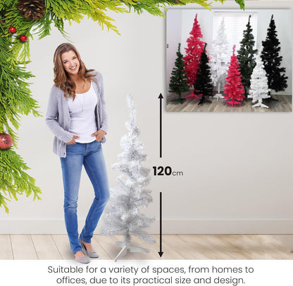 Woman standing next to a small white Christmas tree with a measurement label, surrounded by festive decorations.